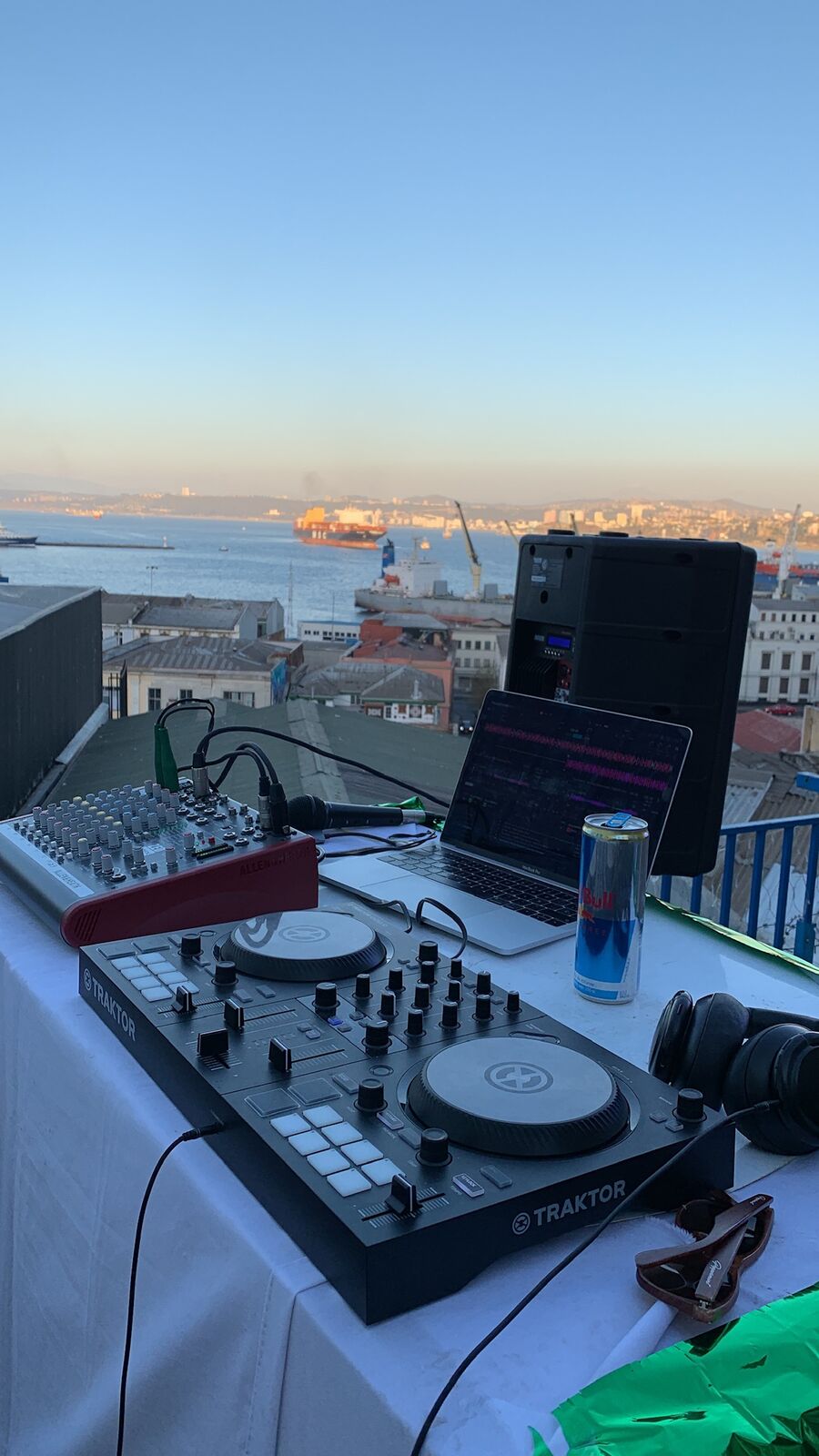 Equipo de DJ en un rooftop al atardecer frente a la bahía